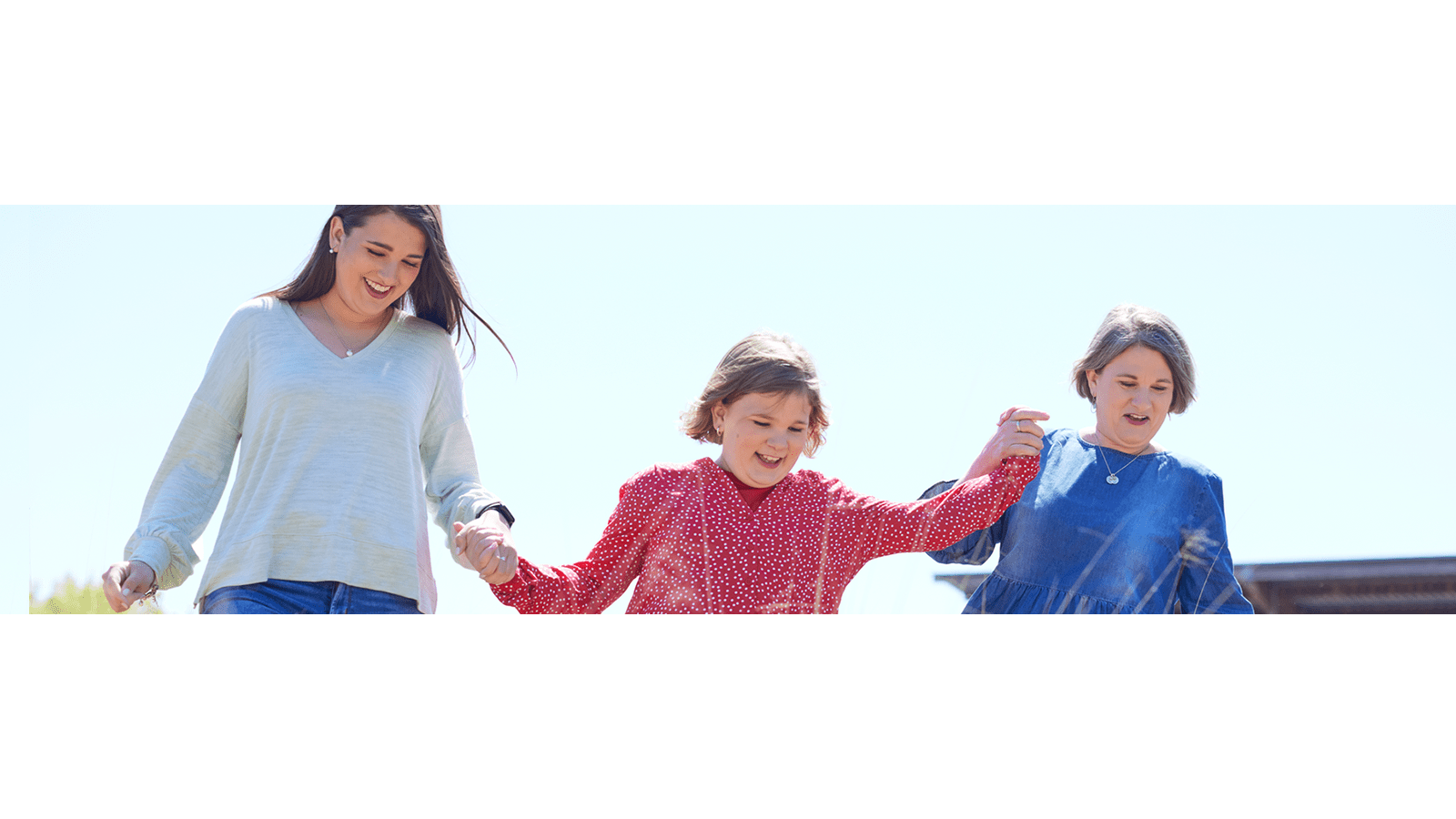Grand-mère, mère et jeune fille marchant ensemble.