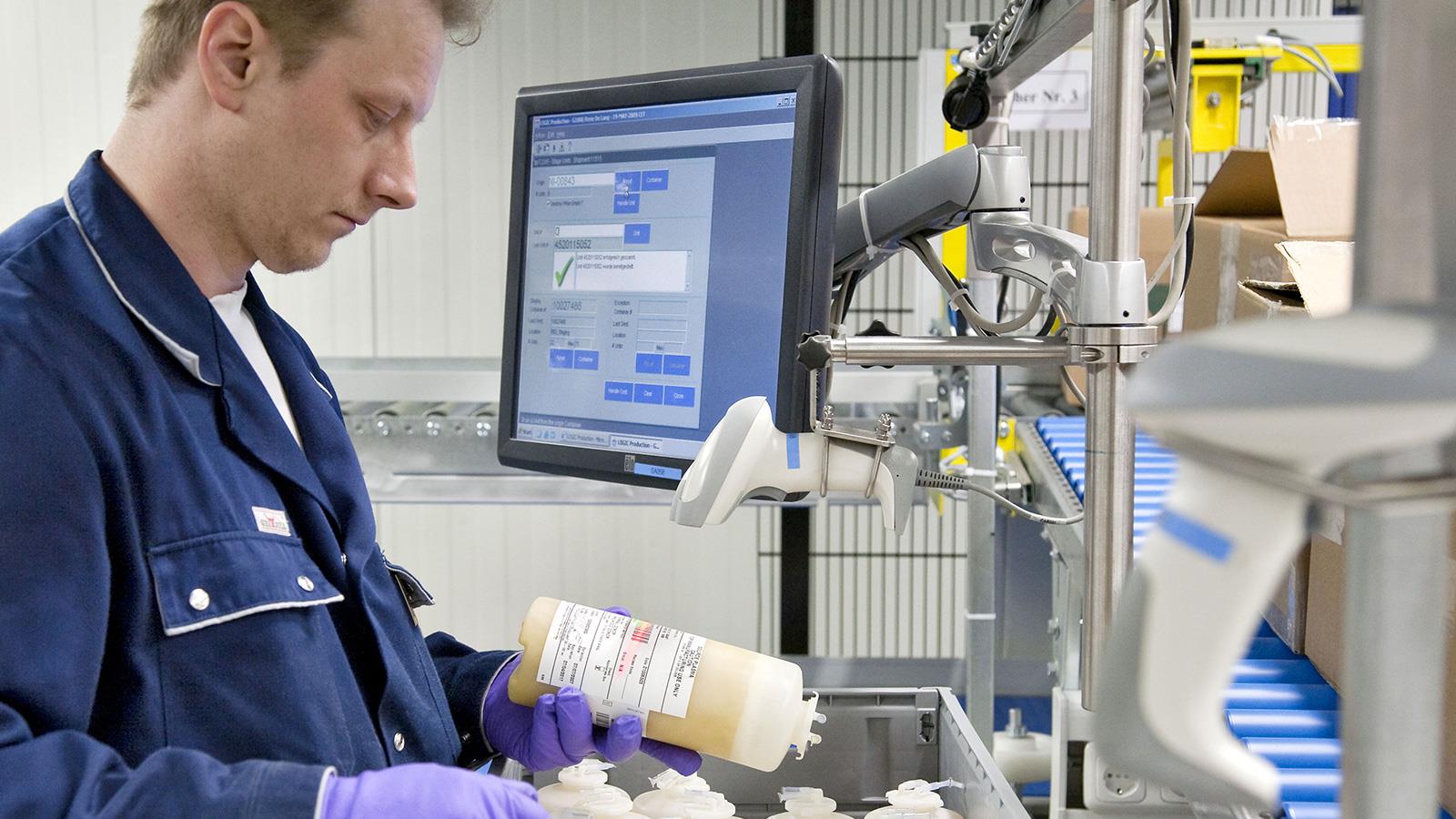 Employé de CSL Plasma scanne bouteille