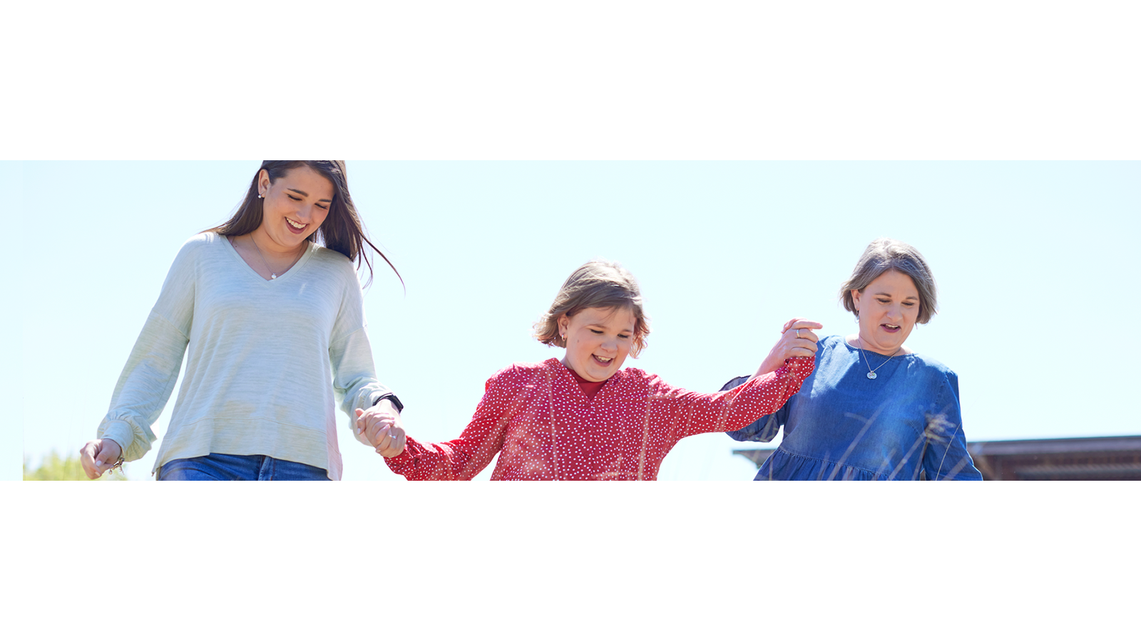 Grand-mère, mère et jeune fille marchant ensemble.